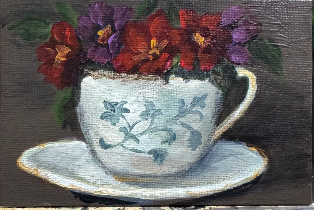Painting of a teacup with floral design and flowers on a dark background