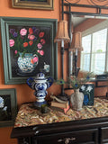Original tulip still life painting in green and white vase, framed and displayed in styled interior setting