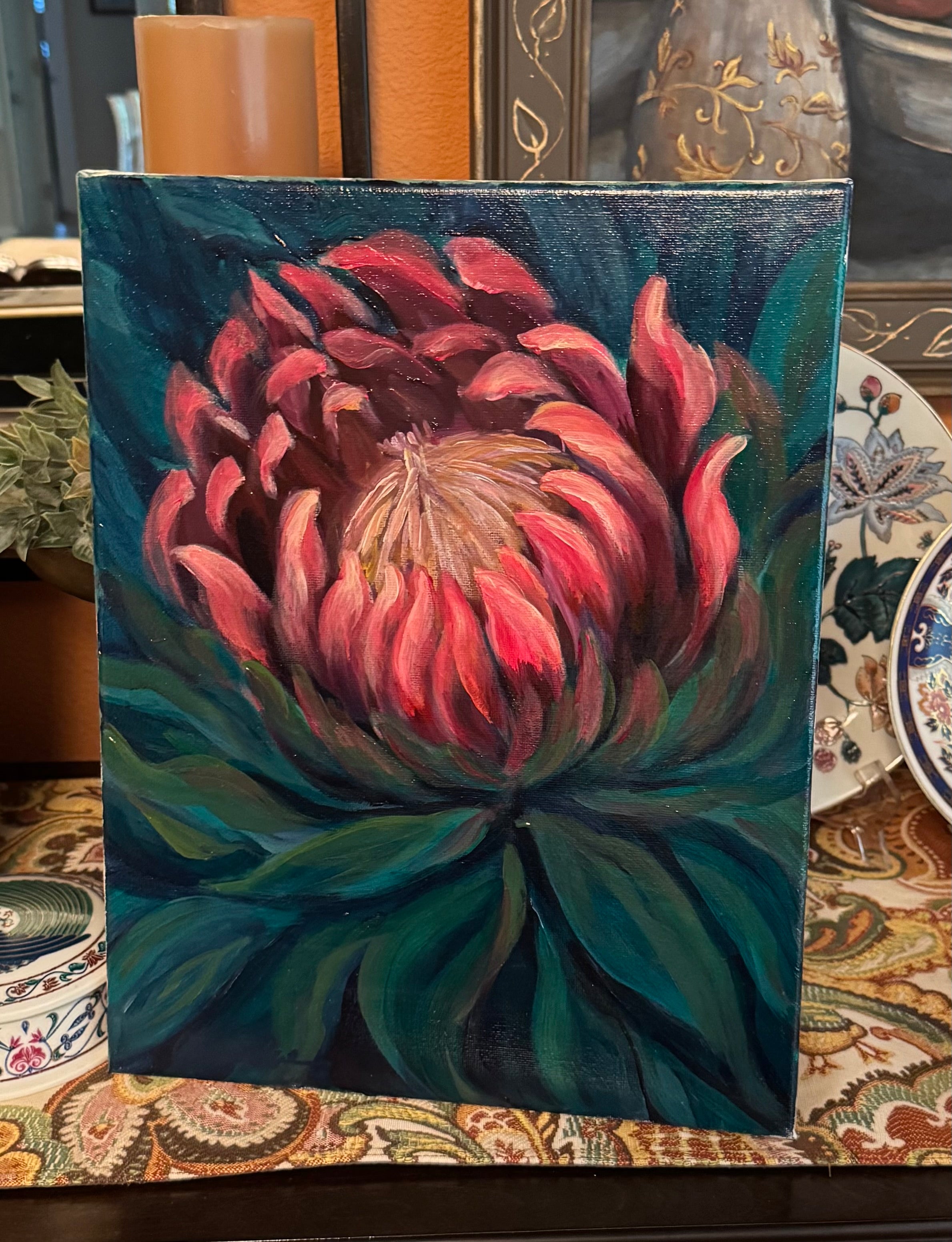 Painting of a pink protea flower with green leaves on a textured surface